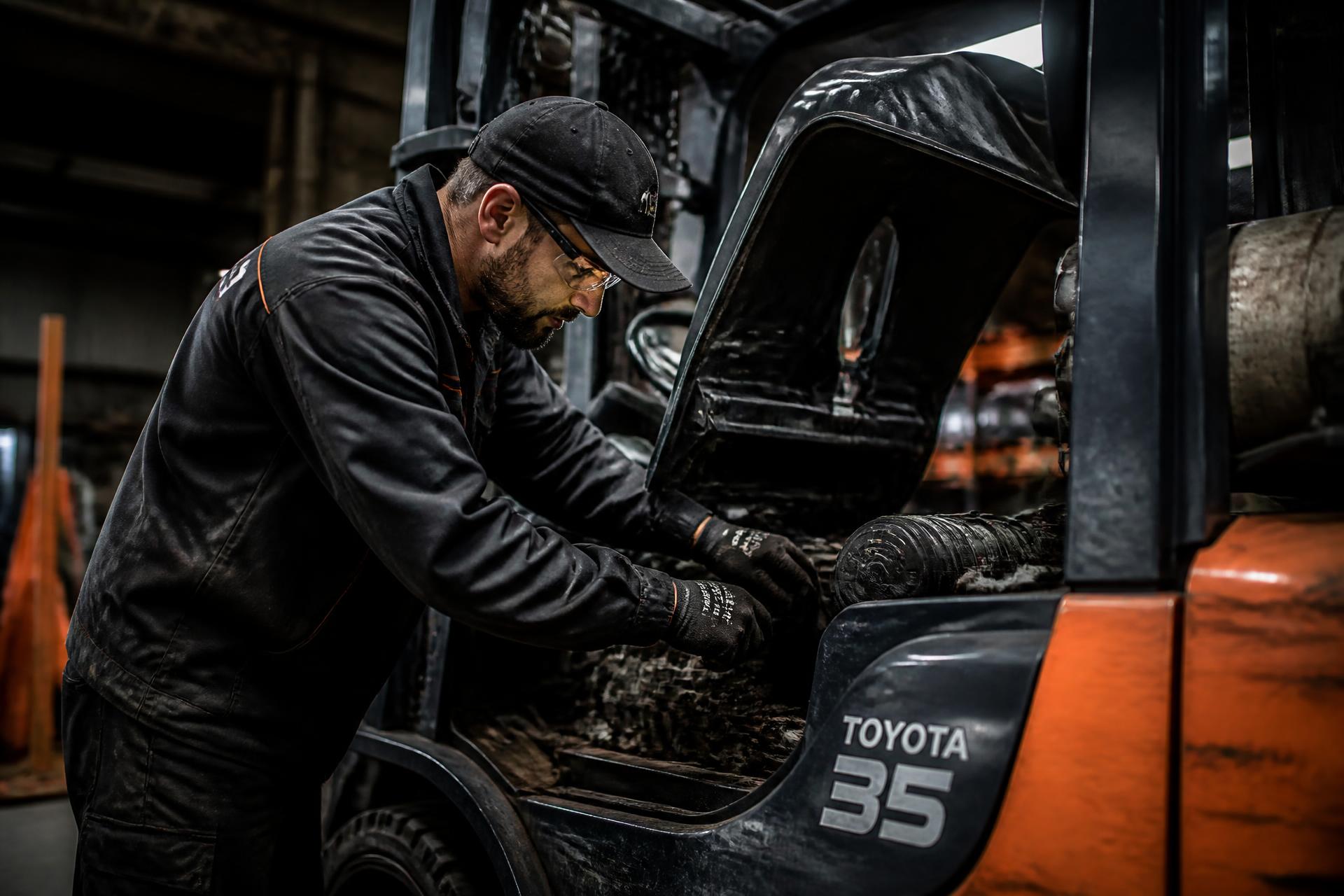 Technician performing forklift maintenance